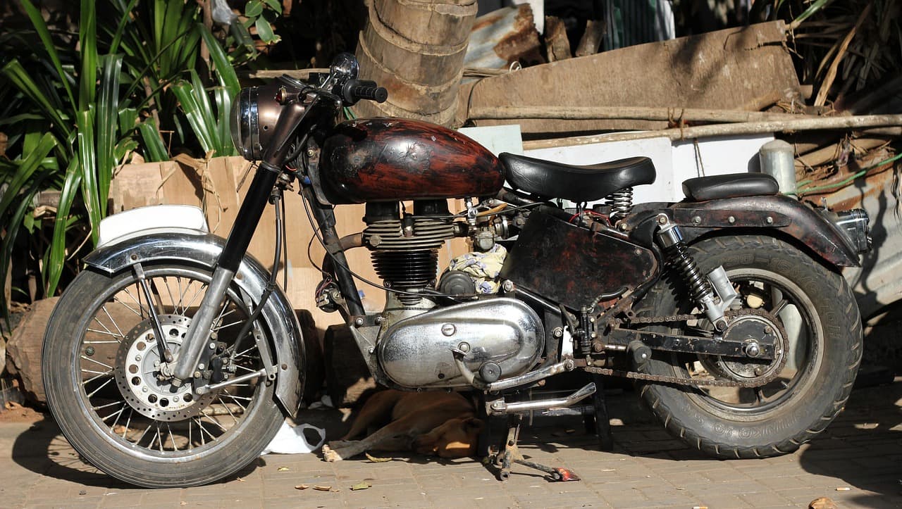 An older motorcycle parked up on a brick yard